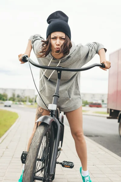 Menina jovem hipster com bicicleta preta — Fotografia de Stock