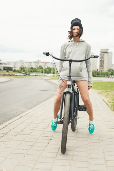 Giovane ragazza hipster con bici nera — Foto Stock