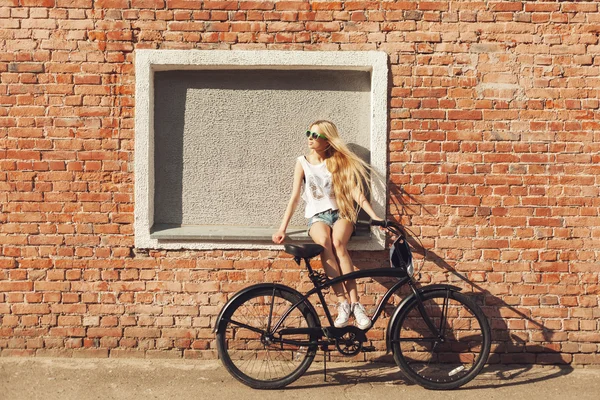 Bela jovem mulher com bicicleta ao ar livre — Fotografia de Stock