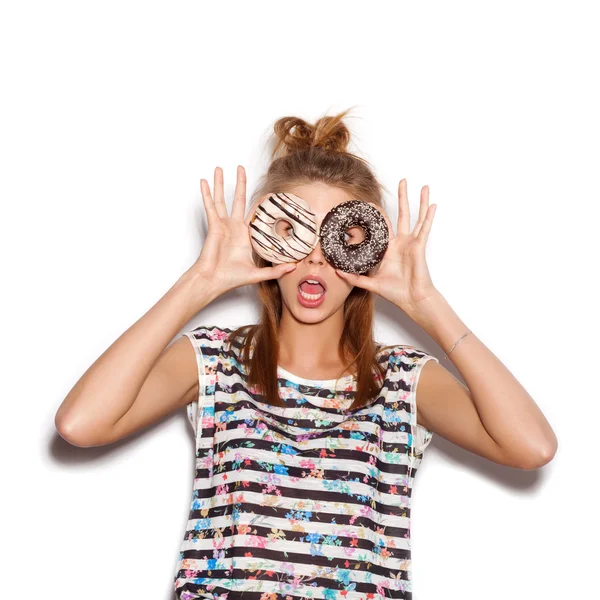 Menina brincalhão segurando donuts em seus olhos — Fotografia de Stock