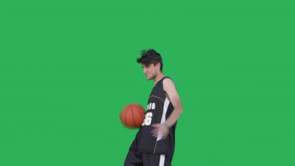 Крупный План Баскетболиста Спортивной Одежде Делающего Трюки Мячом Зеленом Фоне — стоковое видео