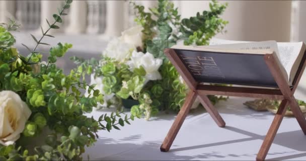 Keresztény biblia virágokkal az asztalon — Stock videók
