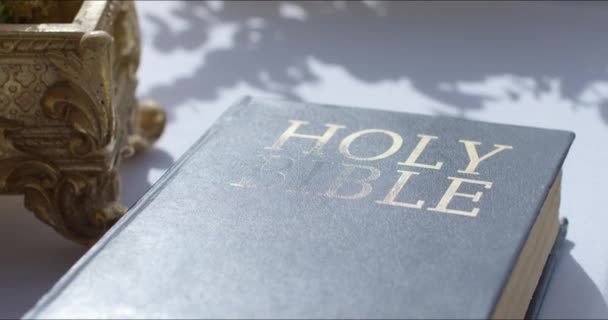Biblia chrześcijańska z kwiatami na stole — Wideo stockowe