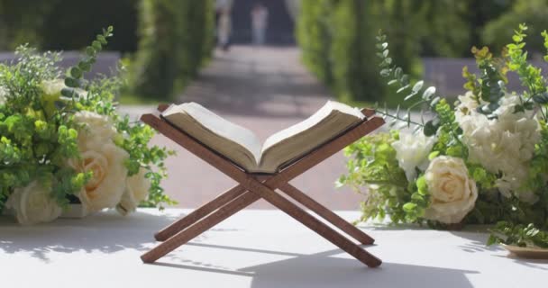 テーブルの上に花とキリスト教の聖書 — ストック動画