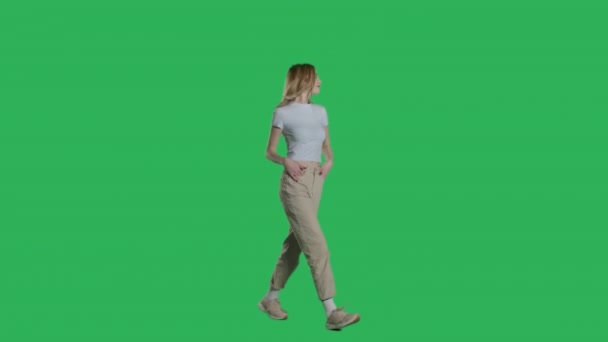 Mujer en camiseta blanca, jeans y zapatillas de deporte caminando — Vídeos de Stock