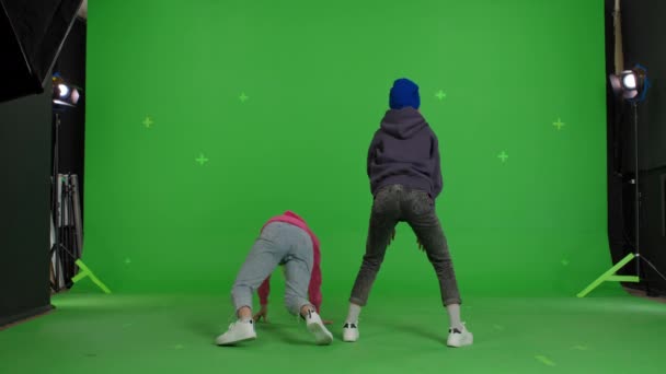Two girls dancing over green screen background — стоковое видео