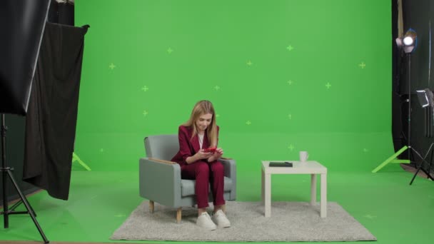 Girl reading good news on phone over green screen — Stock Video