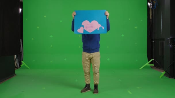 Ekose gömlekli yakışıklı adam kağıt poster tutuyor. — Stok video