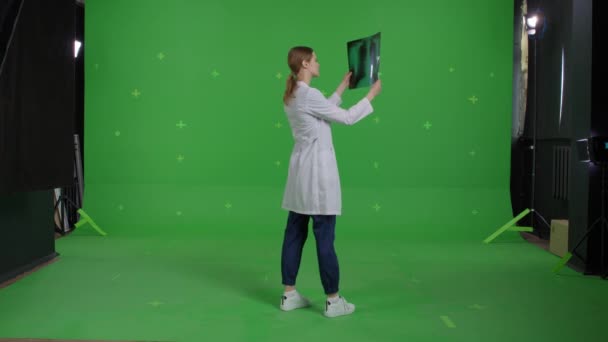 Νεαρή επαγγελματίας γιατρός που εξετάζει μια ακτινογραφία — Αρχείο Βίντεο