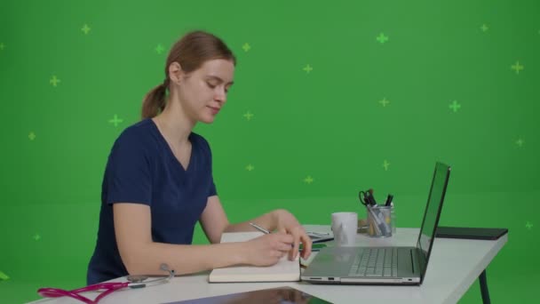 Vit kvinnlig läkare sitter vid sitt skrivbord — Stockvideo
