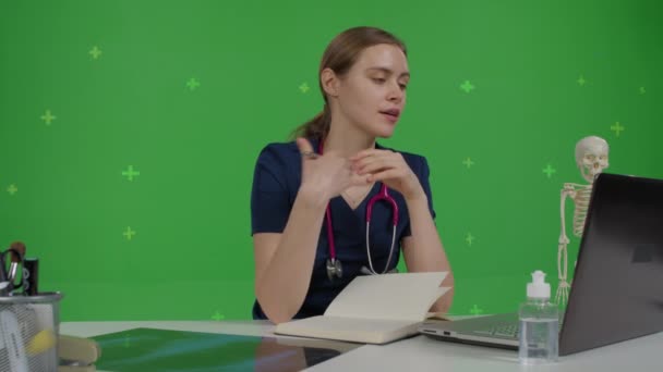 Caucasiana médica senta-se em sua mesa — Vídeo de Stock