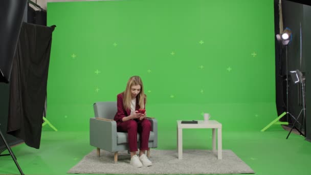 Κορίτσι ανάγνωση καλά νέα στο τηλέφωνο πάνω από την πράσινη οθόνη — Αρχείο Βίντεο