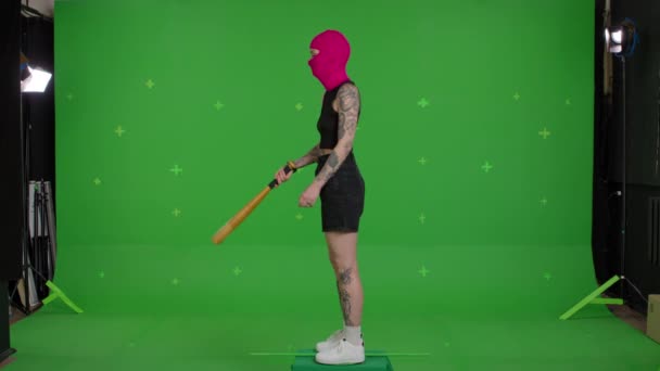 Young woman in pink balaclava with baseball bat — Stock Video