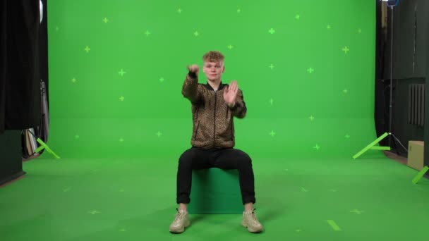 Молодий чоловік танцює на фоні зеленого екрану — стокове відео