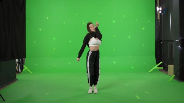 Молода жінка танцює на фоні зеленого екрану — стокове відео