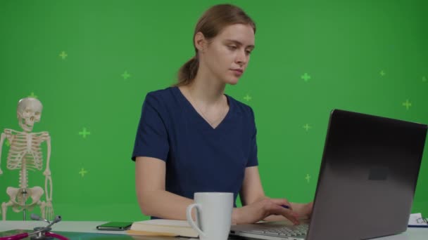 Caucasico medico femminile si siede alla sua scrivania — Video Stock