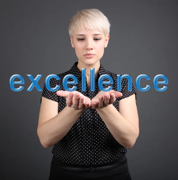 Business woman holding Excellence sign - finance concept — Stock Photo, Image