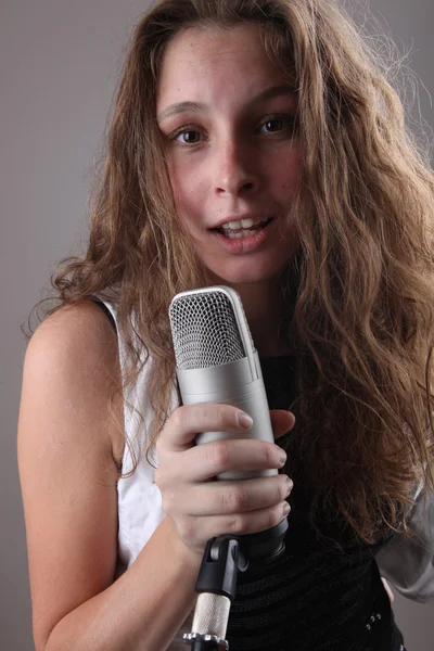Retrato de uma menina com um microfone — Fotografia de Stock