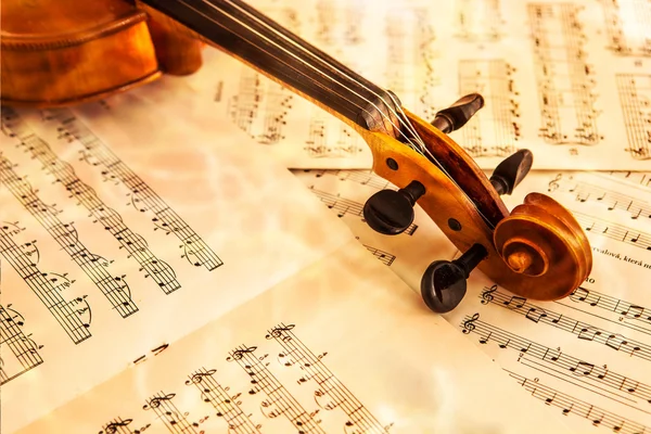 Oude viool liggend op het blad van de muziek — Stockfoto