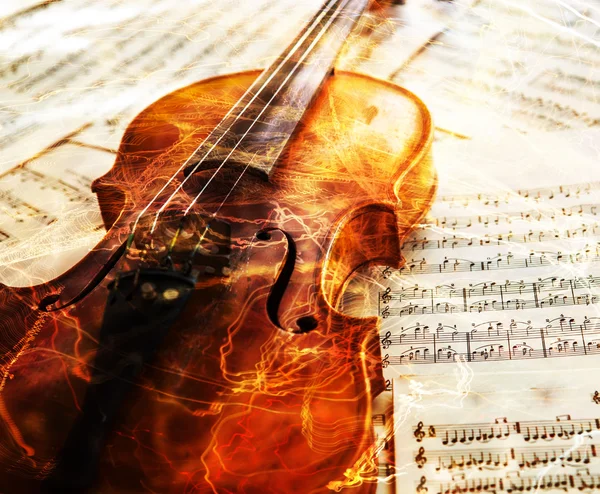 Old violin lying on the sheet of music — Stock Photo, Image