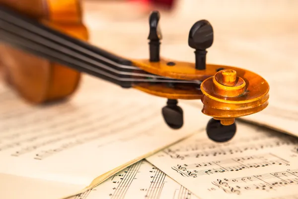 Oude viool liggend op het blad van de muziek — Stockfoto