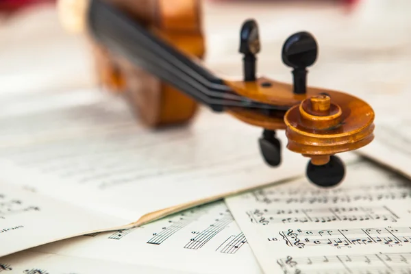 Oude viool liggend op het blad van de muziek — Stockfoto