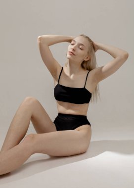 Hafif arka planda mayo giymiş güzel bir sarışın.