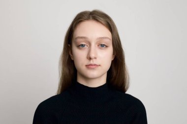 Siyah balıkçı yaka kazaklı, arka planda üzgün bir kız.