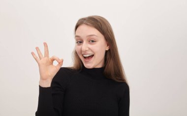 Genç kız mutlu bir şekilde gülümsüyor.