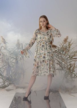 Çiçek desenli uzun bahar elbisesi içinde güzel bir kız.