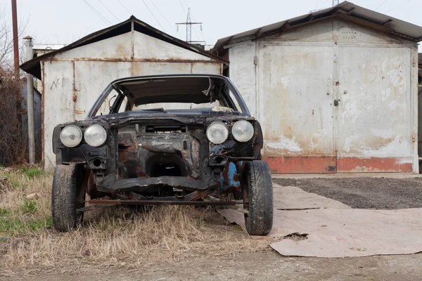 Eski hurda araba sokakta duruyor.