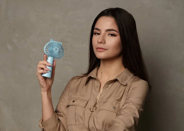 Güzel esmer, klasik makyajlı küçük bir yelpaze tutuyor.