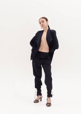 Beyaz arka planda siyah takım elbiseli güzel bir kız.