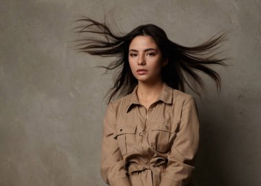 Güzel esmer, uzun saçlı rüzgârda uçan