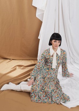 gentle girl in a long vintage dress posing on the floor