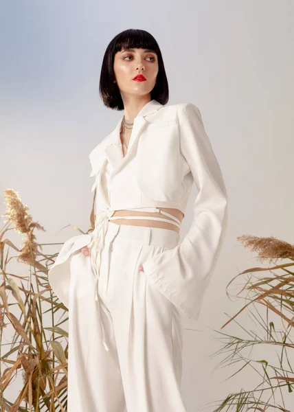 portrait of a beautiful brunette in a trendy white suit