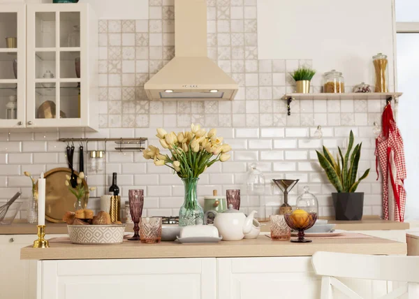 Parlak bir mutfakta güzel dekore edilmiş yemek masası.