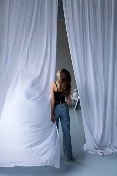 Açık kotlu ve siyah bluzlu ince bir kız.