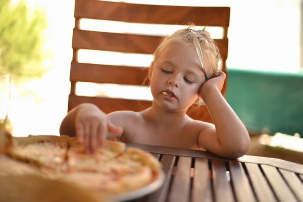 Glückliches kleines Mädchen isst Pizza — Stockfoto