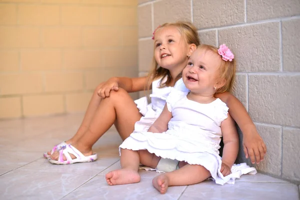 Две маленькие сестры играют вместе. Сосредоточься на малыше . — стоковое фото
