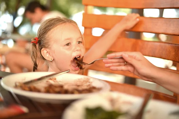 Маленька дівчинка їсть млинець — стокове фото