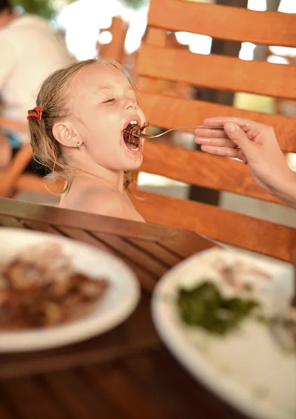Маленька дівчинка їсть млинець — стокове фото