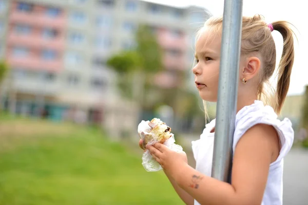 Hübsches kleines Mädchen isst ein Sandwich isoliert auf weißem Hintergrund — Stockfoto
