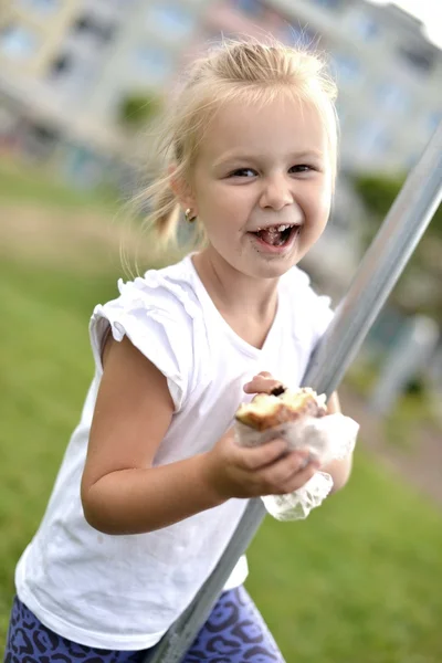 Досить маленька дівчинка їсть бутерброд — стокове фото