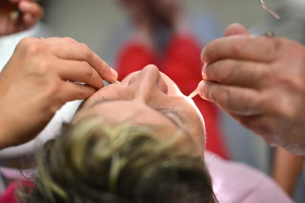 Dentista e seu assistente realizando um exame minucioso — Fotografia de Stock