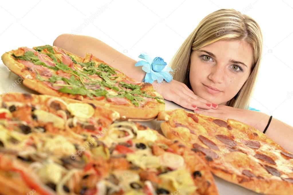 Young woman eating a piece of pizza against a white background
