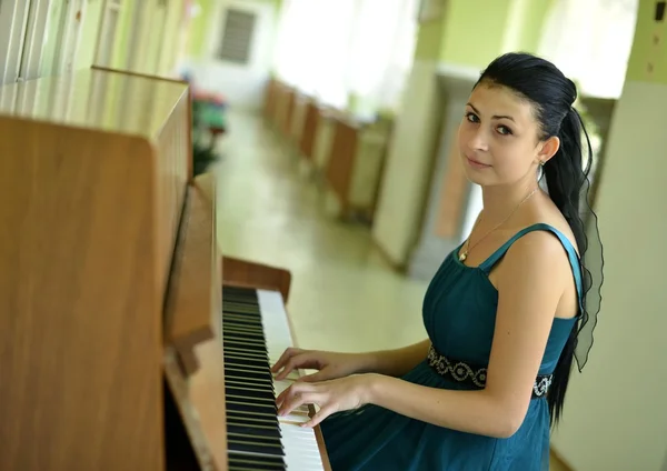 Beautiful young attractive woman in cocktail dress and piano — Stock Photo, Image