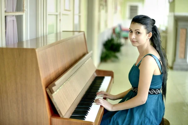 Beautiful young attractive woman in cocktail dress and piano — Stock Photo, Image