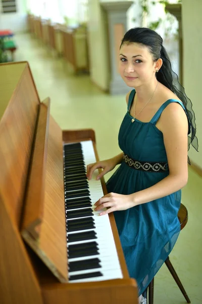 Bella giovane donna attraente in abito da cocktail e pianoforte — Foto Stock