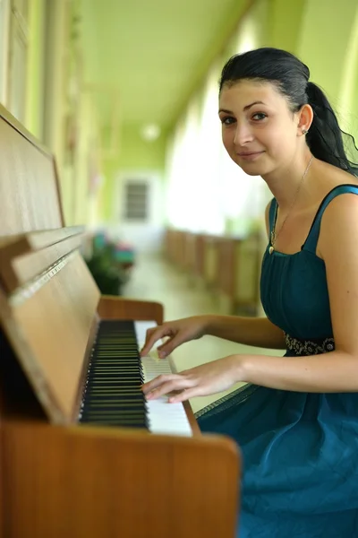 Schöne junge attraktive Frau in Cocktailkleid und Klavier — Stockfoto